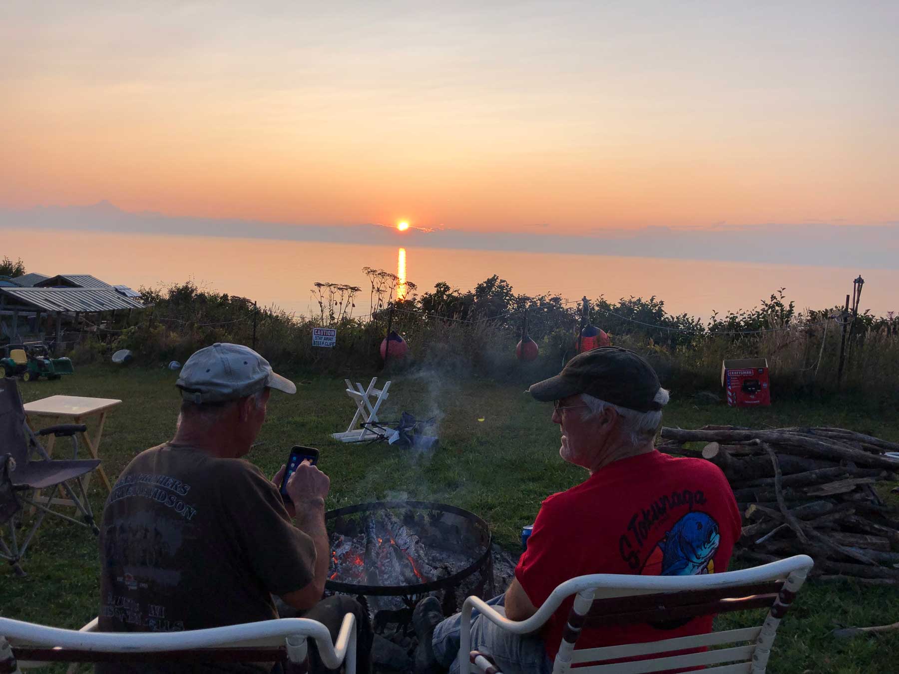 Two gents relaxing by the campfire at sunset