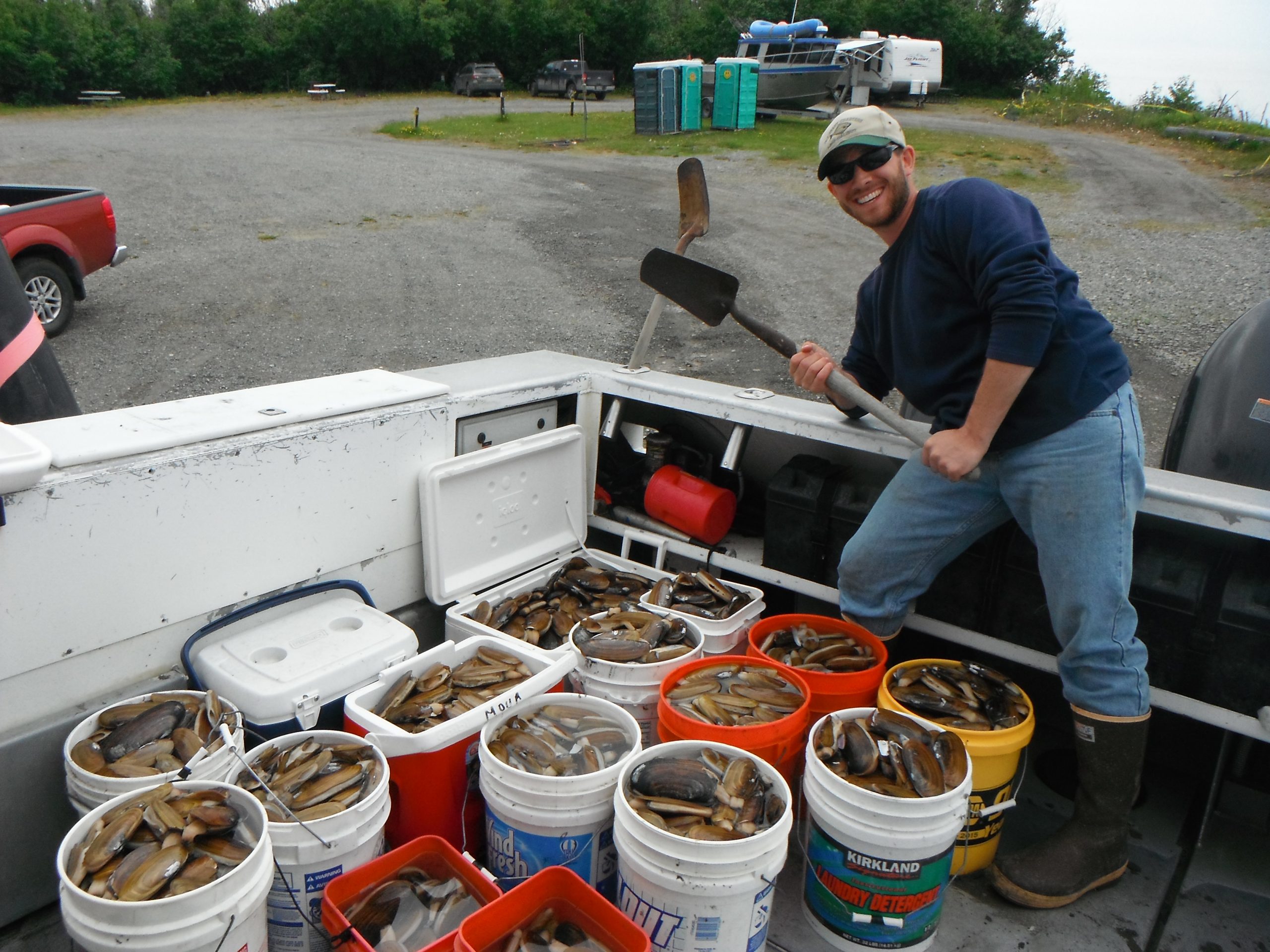 Capt Mike posing with many buckets of clams
