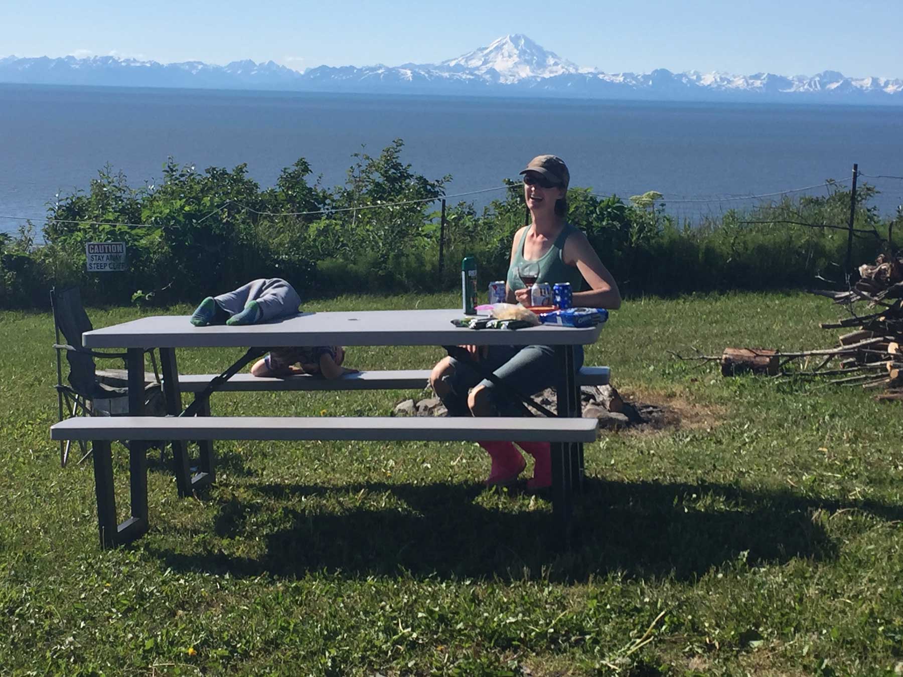 Woman and child eating at a picnic table at the campground