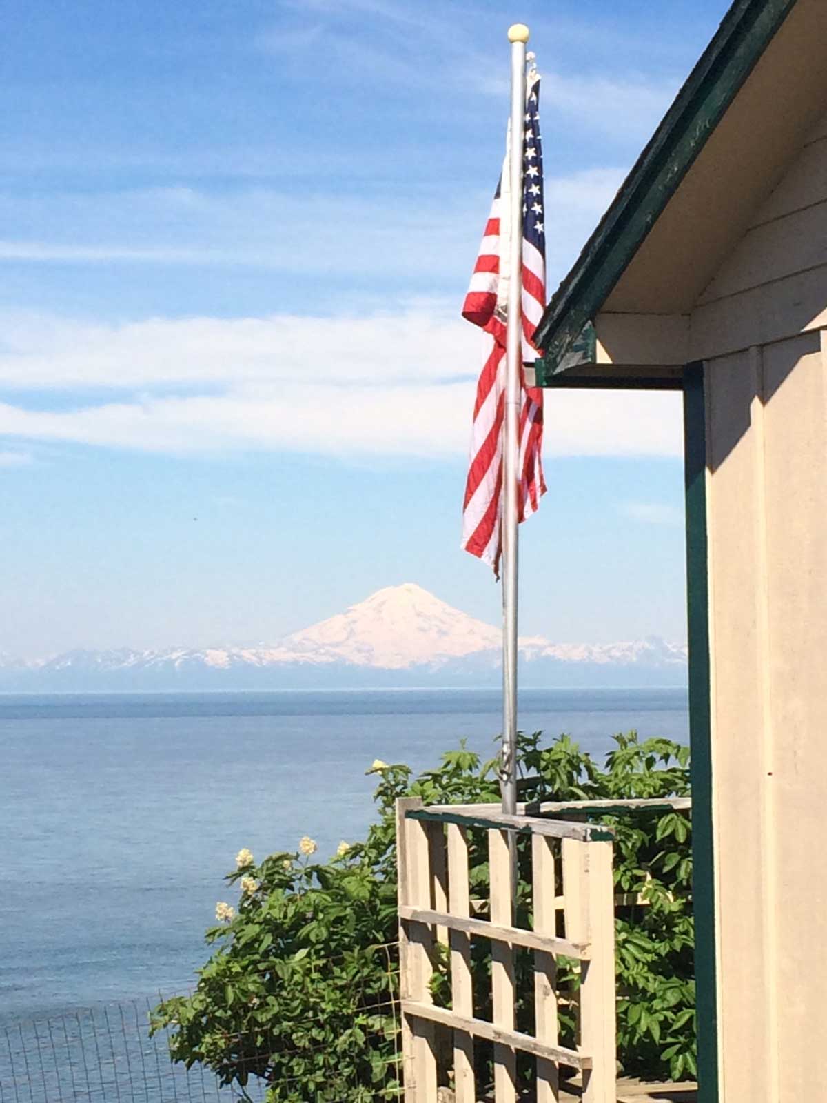 A flag on one of our cabins with a snow covered mountain in the background